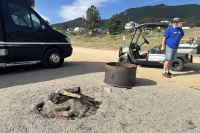 Camp host Jim cleaning up messy campfire