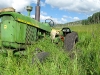 John Deere tractor stuck in the mud while mowing hay