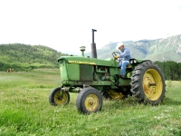 Larry Vickers mows hay on old John Deer tractor