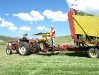 Jim rides the stacker back to the hay barn with a full load